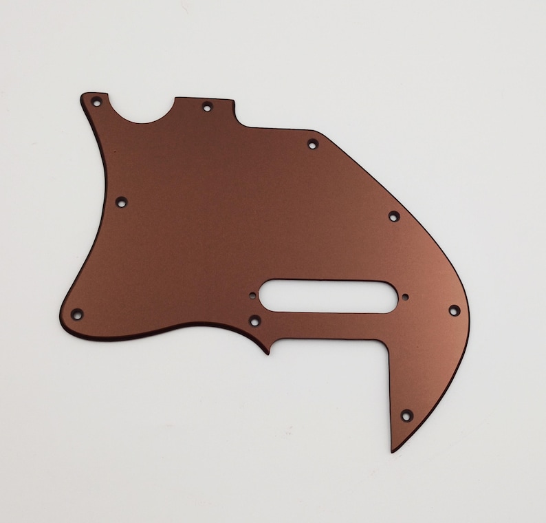 May include: A copper-colored guitar pickguard with multiple screw holes.