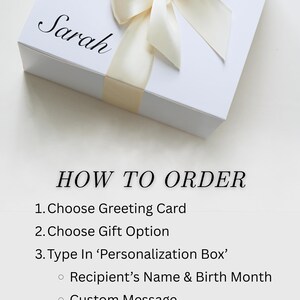 May include: A white gift box with a cream-colored ribbon and bow. The name "Sarah" is written on the box in elegant script. Instructions on how to order are listed below the box.