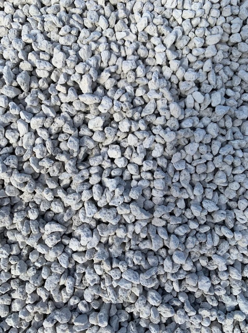 May include: A close-up view of a pile of white lava rocks. The rocks are small and irregular in shape, with a rough, porous texture.
