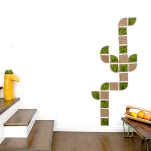 May include: A wall-mounted modular art piece composed of square and curved wooden frames filled with green preserved moss, arranged in a vertical, branching pattern. The design features natural wood textures and vibrant green foliage elements.