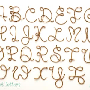 May include: A complete set of twenty-six uppercase English alphabet letters formed from twisted brown rope. Each letter is rendered in a cursive script style. The text "Capital letters" appears in the bottom left and "Arcina" in the bottom right.