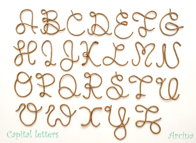 May include: A complete set of twenty-six uppercase English alphabet letters formed from twisted brown rope. Each letter is rendered in a cursive script style. The text "Capital letters" appears in the bottom left and "Arcina" in the bottom right.