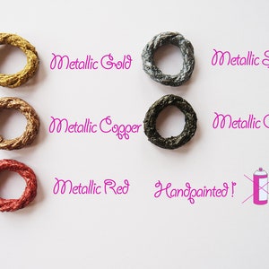 Puede incluir: Seis anillos met&aacute;licos pintados a mano en oro, cobre, rojo, plata y gris. Los anillos est&aacute;n dispuestos en dos filas de tres. El texto "&iexcl;Pintado a mano!" est&aacute; escrito debajo de los anillos.