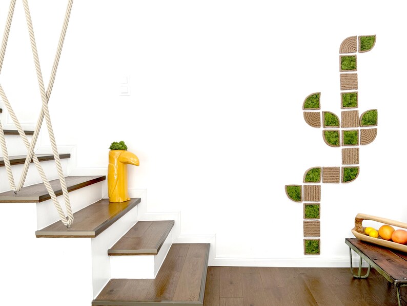 May include: A wall-mounted modular art piece composed of square and curved wooden frames filled with green preserved moss, arranged in a vertical, branching pattern. The design features natural wood textures and vibrant green foliage elements.