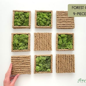 May include: A 9-piece Forest Grid set featuring square frames made of twisted brown rope. Five frames are filled with vibrant green preserved moss, while four frames are filled with horizontal or vertical rows of the same twisted brown rope.