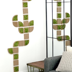 May include: A wall-mounted decorative art piece shaped like a cactus, constructed from modular square and curved segments. Each segment features a combination of natural tan rope coiled in a textured pattern and vibrant green preserved moss.