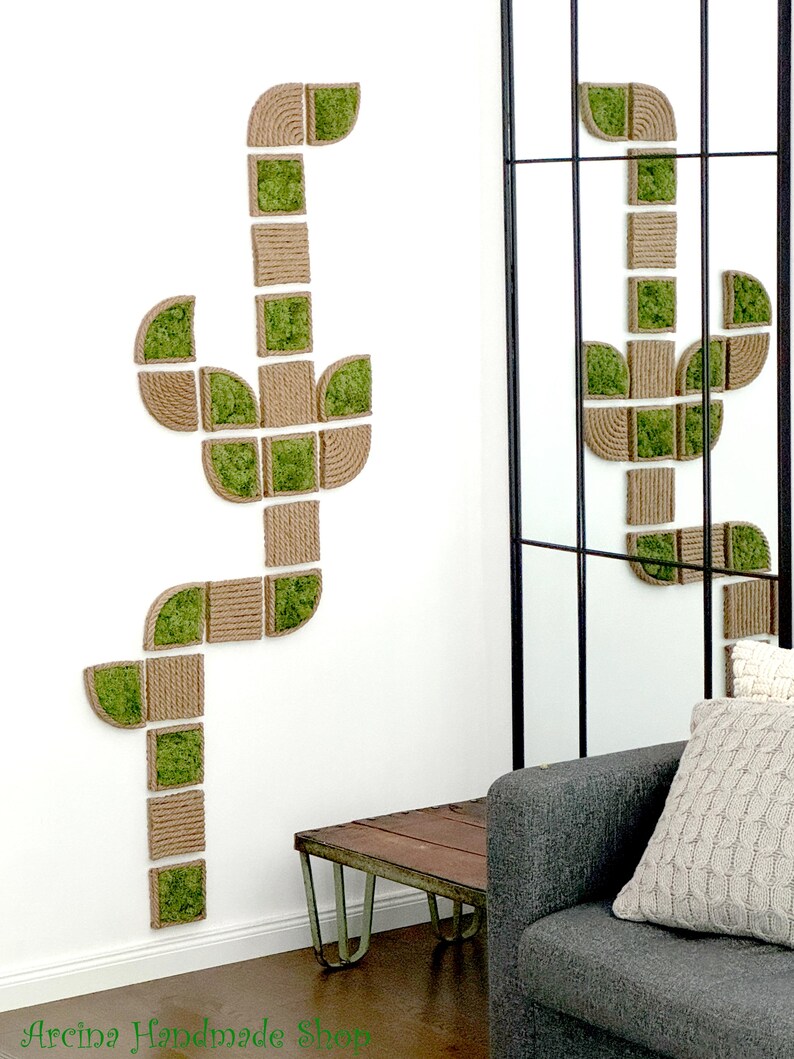 May include: A wall-mounted decorative art piece shaped like a cactus, constructed from modular square and curved segments. Each segment features a combination of natural tan rope coiled in a textured pattern and vibrant green preserved moss.