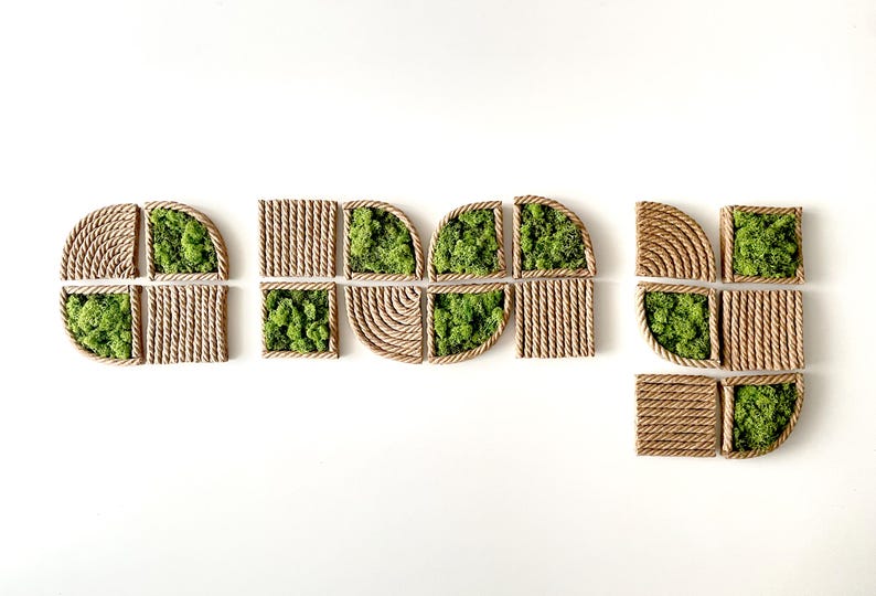 May include: A collection of modular wall art pieces featuring a combination of natural green preserved moss and tan rope arranged in geometric patterns. The set includes square and quarter-circle shapes with textured rope borders and centers.