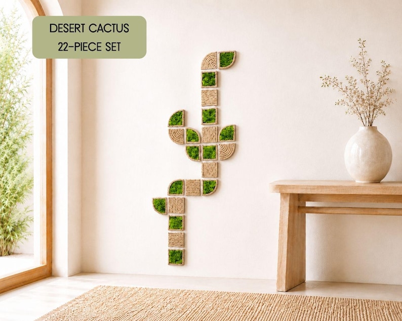 May include: A 22-piece wall art set titled Desert Cactus, composed of square and curved modular tiles featuring natural green moss and coiled tan rope textures arranged in a vertical cactus shape on a plain wall surface.