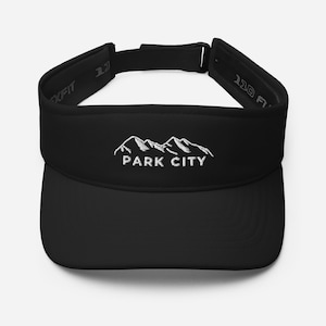Puede incluir: Visera negra con una cordillera de montañas bordada en blanco y el texto "PARK CITY".