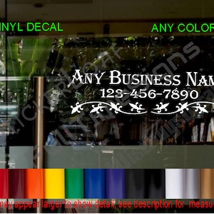 May include: White vinyl decal with a decorative flourish design and the text "ANY BUSINESS NAME" and a phone number "123-456-7890".