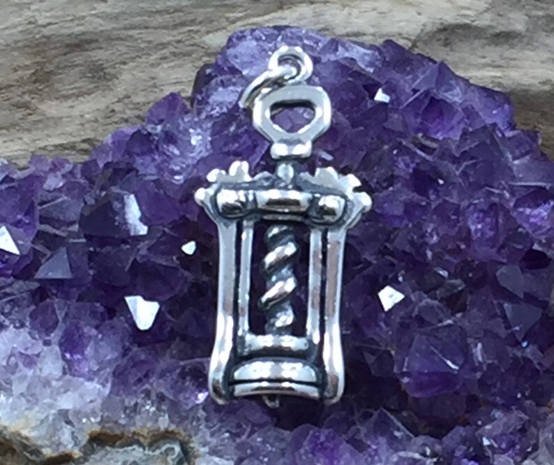 May include: Silver corkscrew charm pendant. The charm is detailed with a corkscrew design and a loop for attaching to a necklace or bracelet.