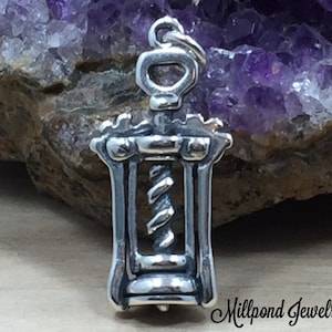 May include: Silver corkscrew charm with a detailed design. The charm is a traditional style corkscrew with a handle and a spiral.