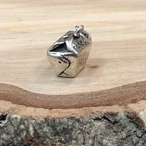 May include: Silver charm in the shape of a takeout container with the word "Takeout" on the side.