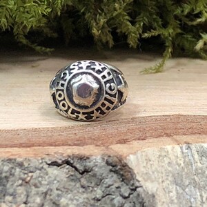 May include: A silver ring with the words "School High" engraved around the band. The ring has a star design and a raised center.