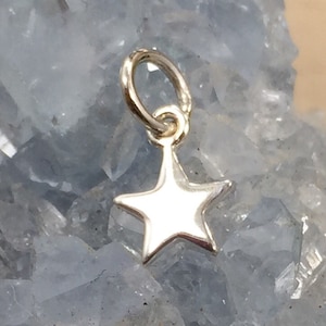 May include: A silver star charm with a loop for attaching to a necklace or bracelet.