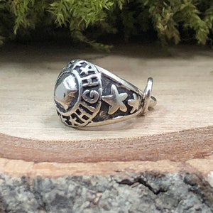 May include: A silver charm in the shape of a class ring with the word "HIGH" engraved on the side and three stars on the band.