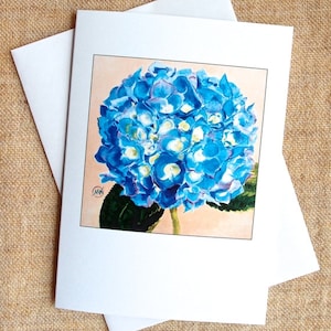 May include: A blue hydrangea flower with white centers, painted in watercolor on a card with a peach background.