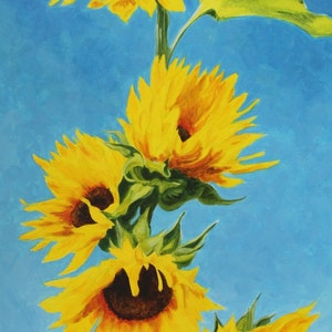May include: A painting of sunflowers with bright yellow petals and dark brown centers against a light blue background. The sunflowers are in various stages of bloom, with green leaves. The artwork is signed in the bottom right corner.