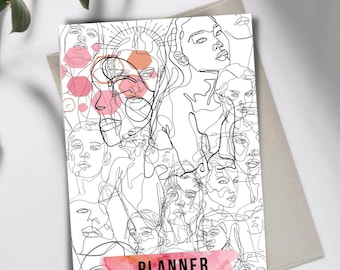 Könnte beinhalten: Ein Planer-Cover mit einer Schwarzweiß-Zeichnung aus mehreren Gesichtern. Die Gesichter überlappen sich und scheinen miteinander zu verschmelzen. Der Hintergrund ist weiß mit einem rosa Aquarell-Farbverlauf am unteren Rand. Der Text "PLANNER 2022" ist in Schwarz auf dem Aquarell-Farbverlauf gedruckt.