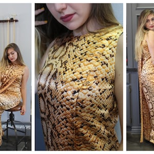 May include: A long, sleeveless maxi dress with a snakeskin print in shades of brown and yellow. The dress has a fitted bodice and a flowing skirt.