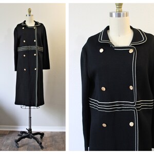 May include: A black double-breasted coat with white piping and gold buttons.