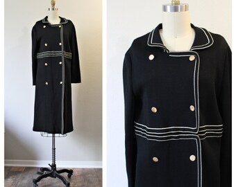 May include: A black double-breasted coat with white piping and gold buttons.