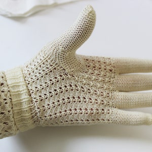 May include: A pair of off-white crocheted gloves with a delicate pattern. The gloves are made of a lightweight, breathable fabric and have a comfortable fit.