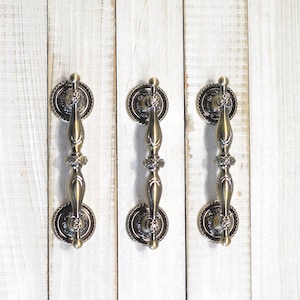 May include: A handmade wooden sign with the text "Welcome to our home" in a handwritten style. The sign is painted white with black lettering and a distressed finish, perfect for home decor.