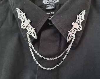 May include: A black collared shirt with two silver bat-shaped collar stays with chains attached.