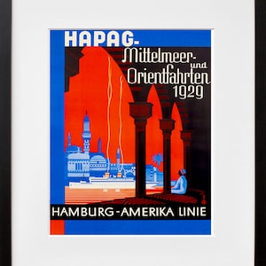 May include: Framed vintage travel poster with text "HAPAG. Mittelmeer- und Orientfahrten 1929" in white. The poster features a blue and red color scheme with illustrations of a city skyline and architectural columns. A person is seated in the lower right corner.