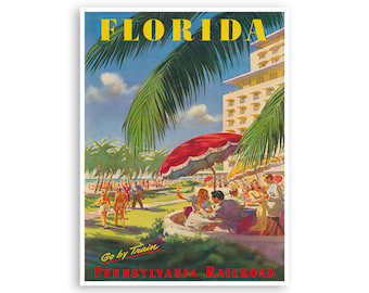 Może przedstawiać: Winietkowy plakat podróżny reklamujący podróż pociągiem do Florydy. Plakat przedstawia kolorową ilustrację sceny plażowej z palmami, hotelem i ludźmi relaksującymi się pod parasolami. Tekst na plakacie brzmi "Florida" i "Go by Train Pennsylvania Railroad".