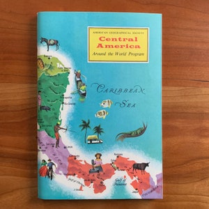以下が含まれることがあります： アメリカ地理学会の「Around the World Program」の「Central America」というタイトルのヴィンテージ本の表紙。表紙には、中央アメリカとカリブ海の地図、地元の風景や野生生物のイラストが描かれています。