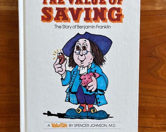 Può includere: Un libro per bambini intitolato "The Value of Saving" con un'illustrazione di Benjamin Franklin che tiene in mano una moneta e un salvadanaio. La copertina presenta un testo arancione e marrone su sfondo bianco, con il nome dell'autore in basso.