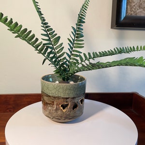 May include: A set of three ceramic mugs with a speckled, matte finish. The mugs are in shades of cream, light gray, and dark gray. Each mug has a simple, minimalist design, perfect for coffee or tea.