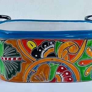 May include: Three rectangular ceramic planters with colorful floral designs. The planters have a white interior and are decorated with intricate patterns in red, orange, blue, green, and black. The planters are ideal for indoor or outdoor use.