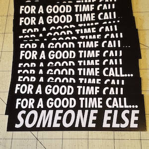 May include: A stack of black and white stickers with the text "For a good time call someone else" repeated multiple times.