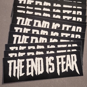 May include: A stack of black and white stickers with the text "THE END IS FEAR" in a bold, white, distressed font.