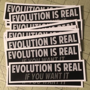 Könnte beinhalten: Ein Stapel schwarzer und weißer Aufkleber mit dem Text "Evolution is real" in weiß auf schwarzem Hintergrund. Der Text wird auf jedem Aufkleber wiederholt. Der untere Aufkleber hat den zusätzlichen Text "If you want it" in weiß auf schwarzem Hintergrund.
