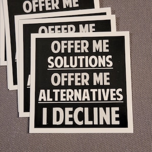 May include: Black and white sticker with the text "Offer me solutions, offer me alternatives, I decline."