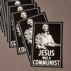 May include: A black and white sticker with an image of Jesus holding a basket of bread. The text on the sticker reads "Jesus was a communist".