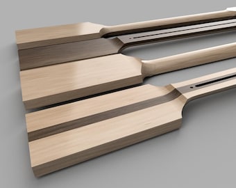 May include: Four wooden oars with a light brown finish are arranged diagonally. Each oar features a paddle-like blade and a long, slender handle. The design includes a dark brown stripe down the center of the oar.