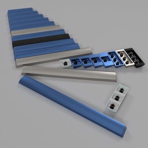 Könnte beinhalten: Ein Satz blauer, grauer und schwarzer Tastaturkappen. Die Tastenkappen sind in einem versetzten Muster angeordnet, wobei die größeren Tastenkappen unten und die kleineren Tastenkappen oben liegen. Die Tastenkappen bestehen aus strapazierfähigem Kunststoff und haben eine glatte, matte Oberfläche.