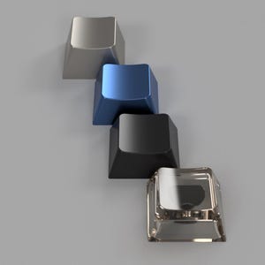 May include: Four different colored keycaps, stacked on top of each other. The keycaps are silver, blue, black, and clear.