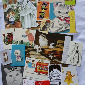 May include: A collection of vintage-style postcards and playing cards featuring various cat illustrations, including a cat in a dress, a cat on a bicycle, a cat with a red bow, a cat on a bus labeled Catnip Tea, and a Garfield playing card.
