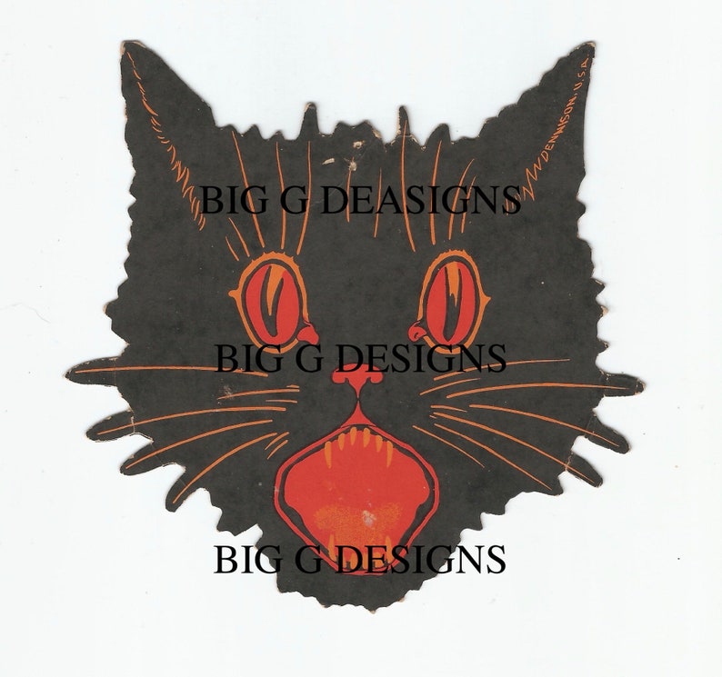 May include: Black paper cutout of a cat's face with large red eyes and an open mouth with red teeth. The cat's whiskers are orange. The text "Dennison U.S.A." is printed on the right side of the cutout.