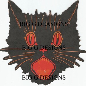 May include: Black paper cutout of a cat's face with large, red eyes and an open mouth showing sharp teeth. The cat's whiskers are orange. The text "Dennison, U.S.A." is printed on the right side of the cutout.