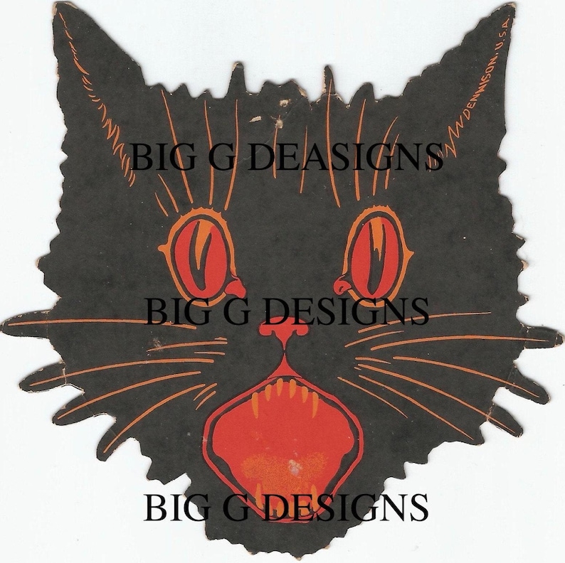 May include: Black paper cutout of a cat's face with large, red eyes and an open mouth showing sharp teeth. The cat's whiskers are orange. The text "Dennison, U.S.A." is printed on the right side of the cutout.