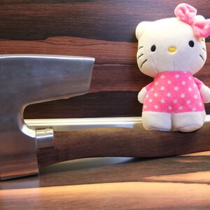 May include: A silver axe with a wooden handle and a pink and white polka dot plush toy sitting on the handle.