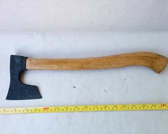 Peut inclure: Une hache noire avec un manche en bois. La hache mesure environ 58 cm de long.